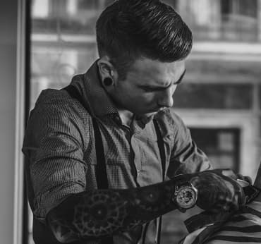 The barber is cutting a client