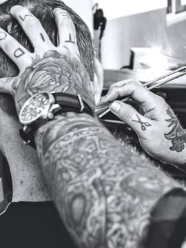 The barber is cutting a client